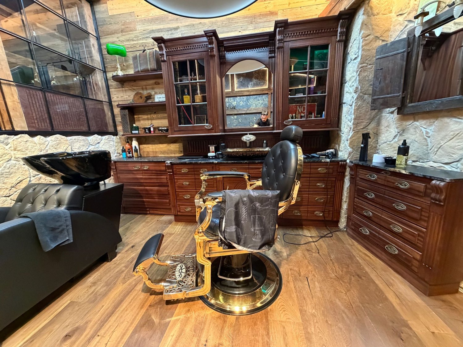 Intérieur du salon Poga — fauteuil doré, bois et pierre